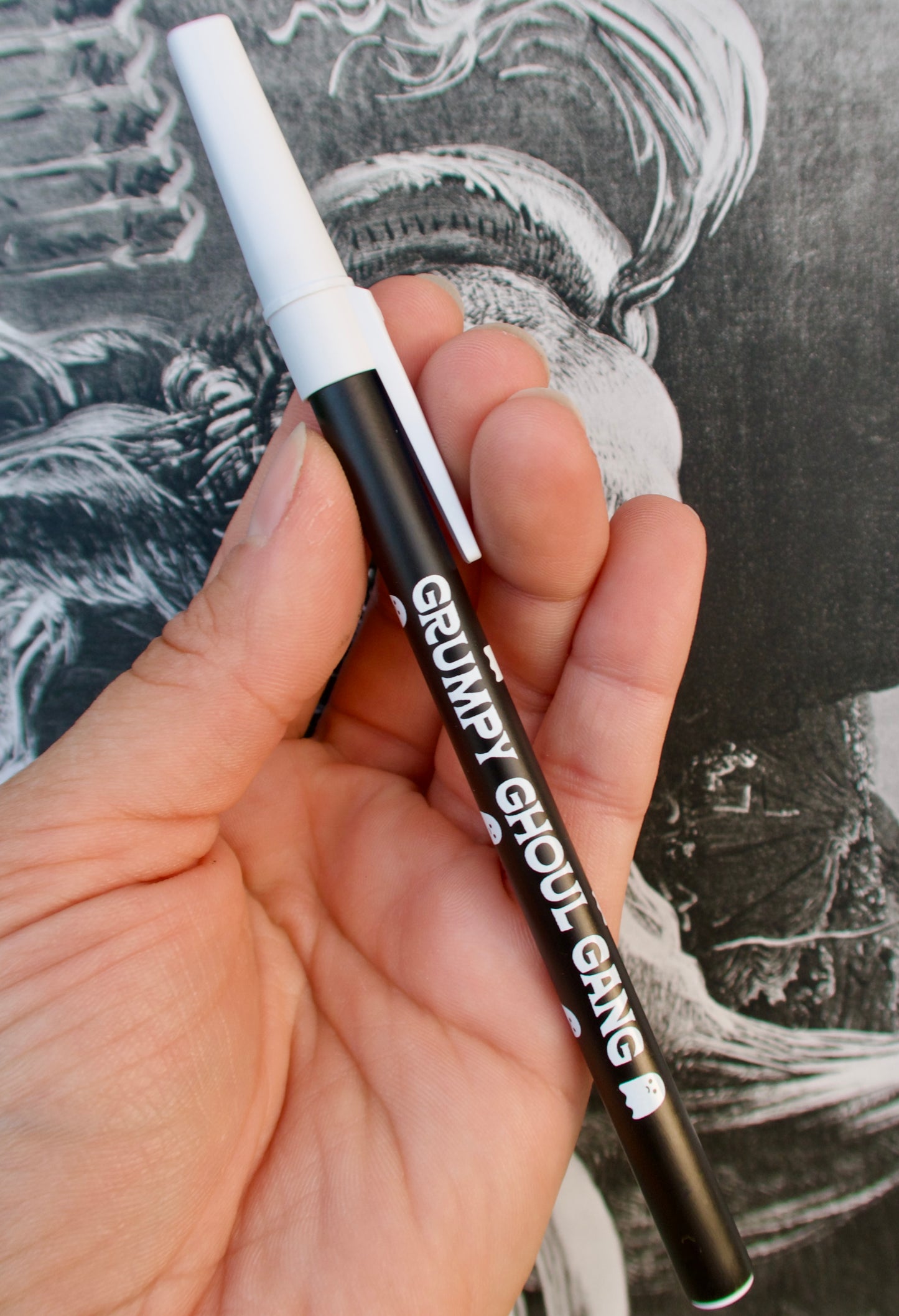 Pen with 'Grumpy Ghoul Gang' branding in front of a black and white illustration.